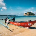 A colorful boat rests on a tranquil Bali beach, capturing the serene and picturesque coastal scenery.